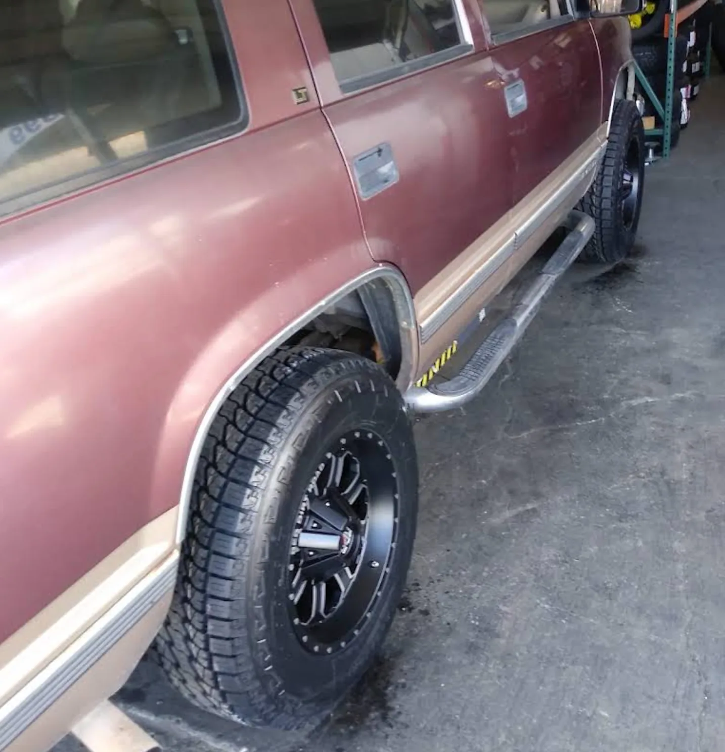 Chevy SUV fitted with black off-road wheels and all-terrain tires