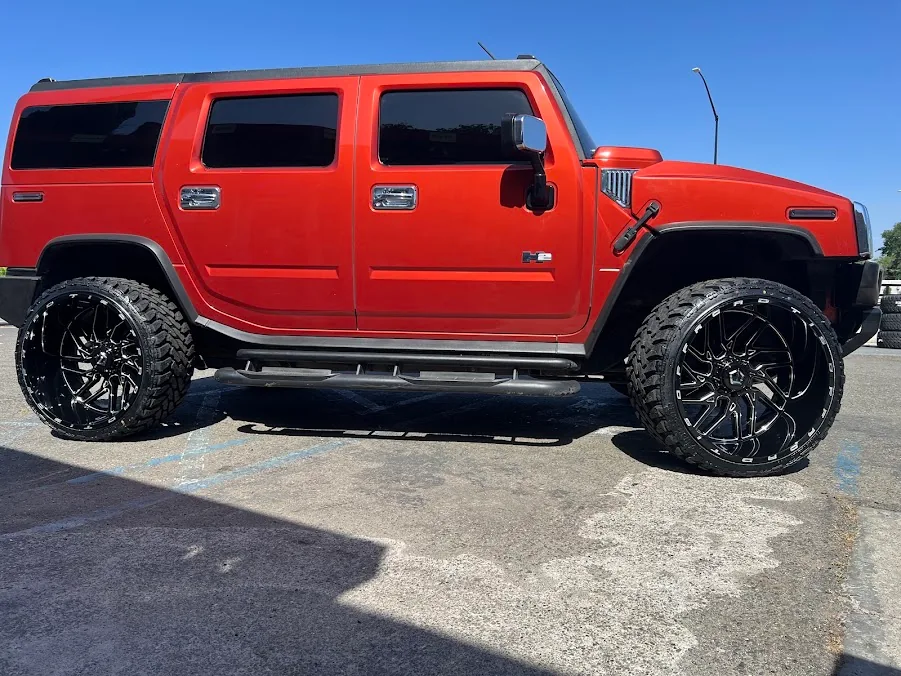 Red Hummer H2 on black custom wheels and off-road tires