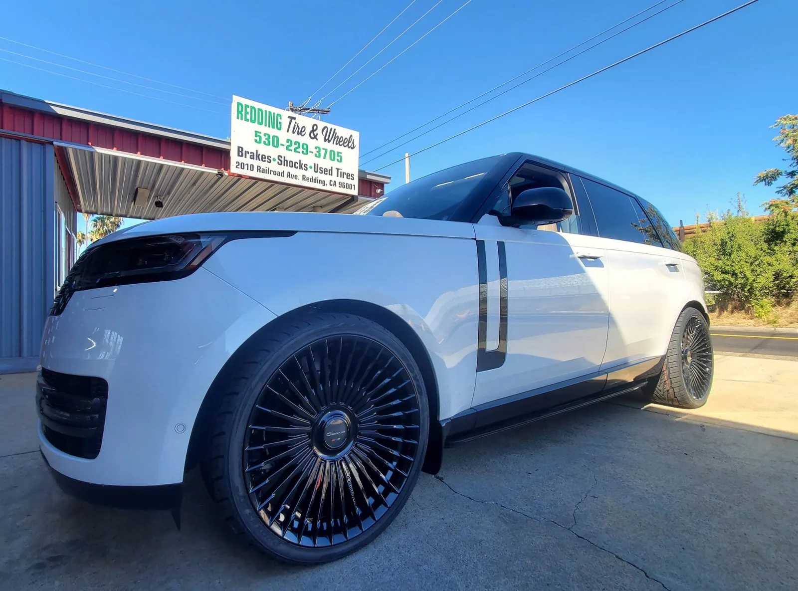 White Range Rover on black multi-spoke custom wheels outside Redding Tires and Wheels